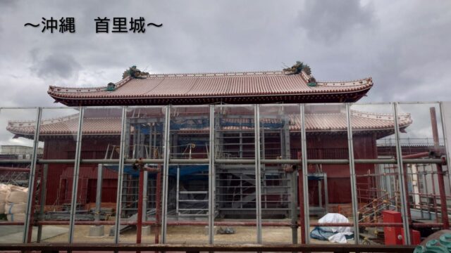 修復工事中の首里城正殿と屋根の上にある龍
