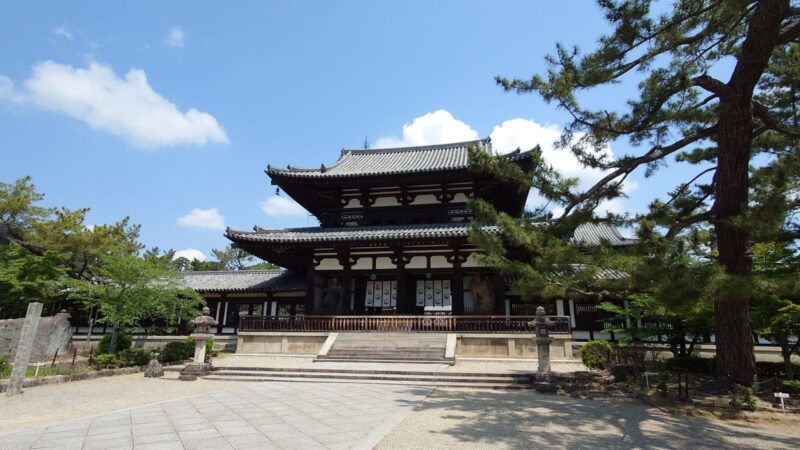 青空を背景に佇む、法隆寺の壮大な南大門と左右に続く土塀