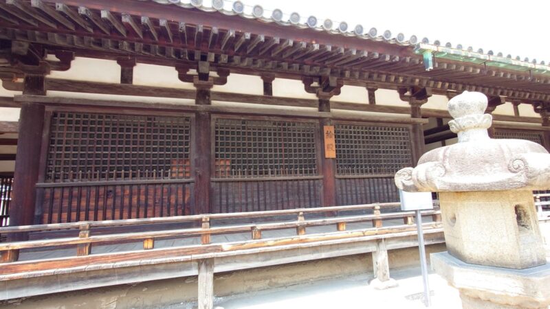 手前に石灯籠が立つ、法隆寺の絵殿（えでの）の外観と木製の看板