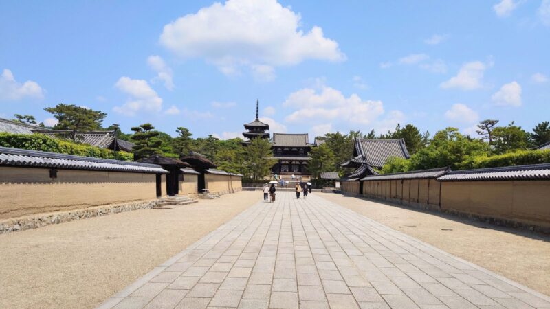 広い石畳の参道の先に、法隆寺の中門と五重塔が見える景色