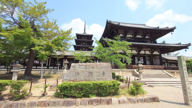 「法隆寺」と書かれた大きな石碑の背景に立つ五重塔と中門