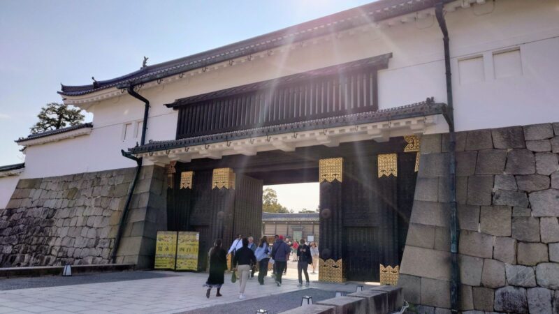 二条城の正門・東大手門をくぐる観光客と差し込む陽光