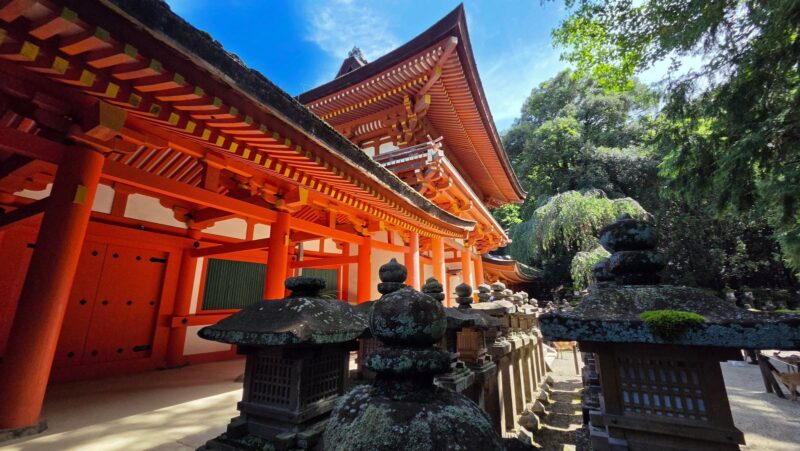 春日大社の南門と朱色の社殿、石灯籠が並ぶ境内